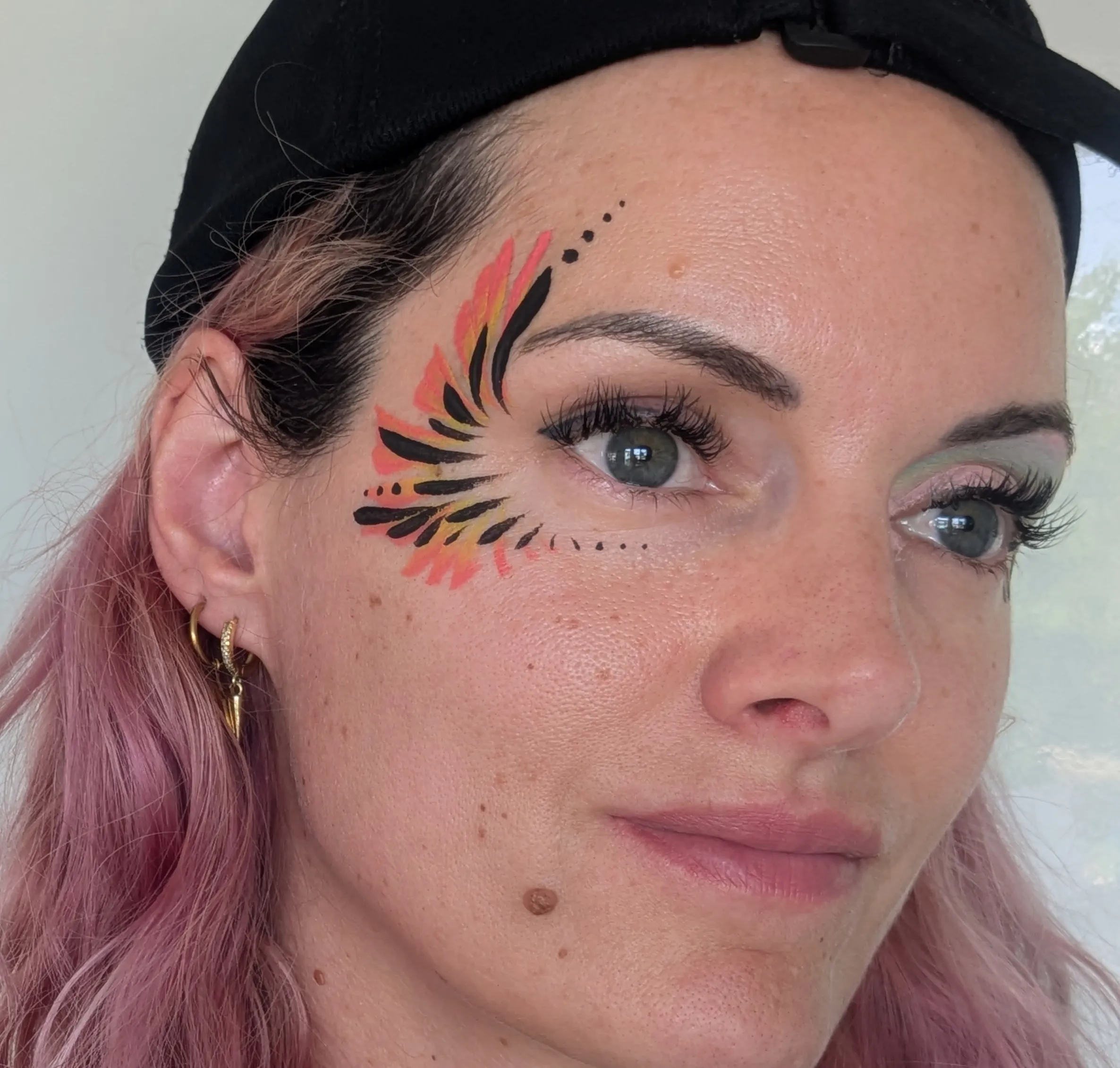 Maquillage artistique coloré pour adulte lors d’un festival